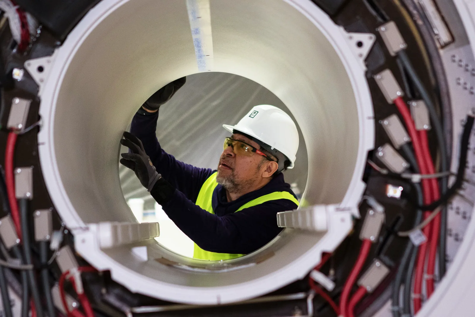 Technician inspecting the inside of an MRI bore